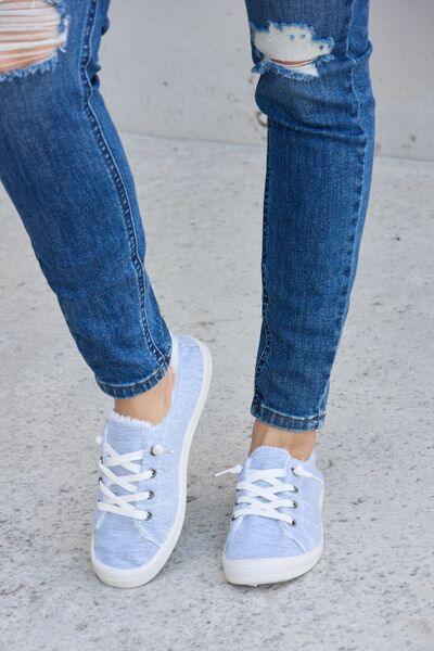 a close up of a person's feet wearing blue sneakers