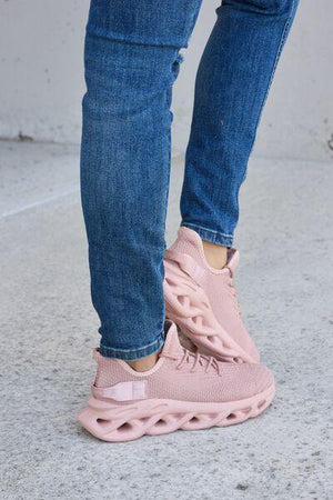 a person wearing pink sneakers and jeans