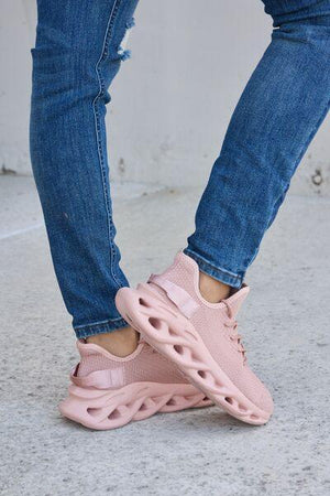 a close up of a person wearing pink sneakers