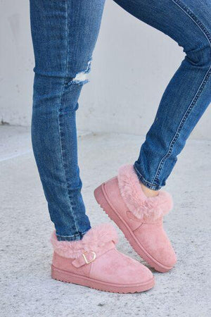 a woman wearing pink slippers and jeans