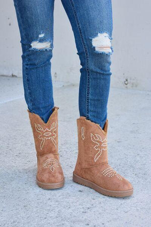 a woman wearing a pair of brown boots