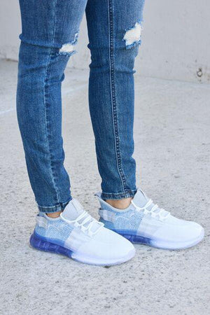 a person wearing ripped jeans and white sneakers