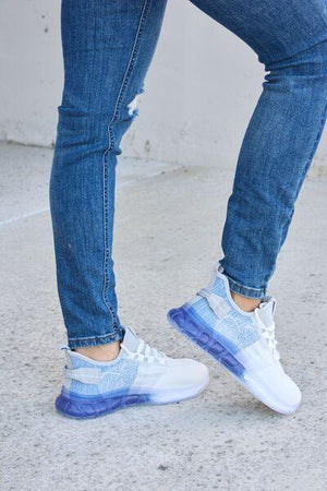 a person wearing blue jeans and white sneakers