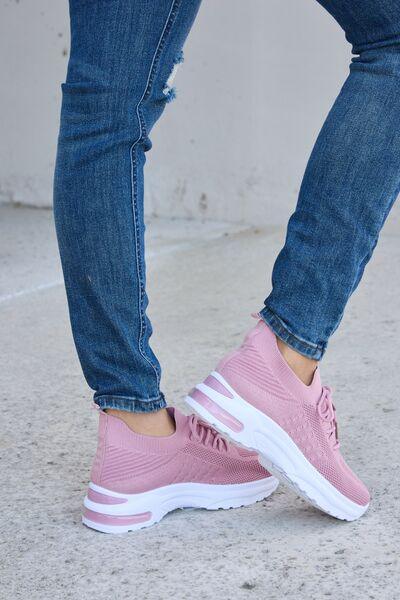 a close up of a person wearing pink sneakers