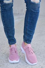 a close up of a person wearing pink sneakers