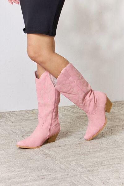 a close up of a woman wearing pink cowboy boots