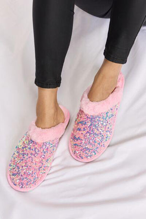 a close up of a person wearing pink slippers