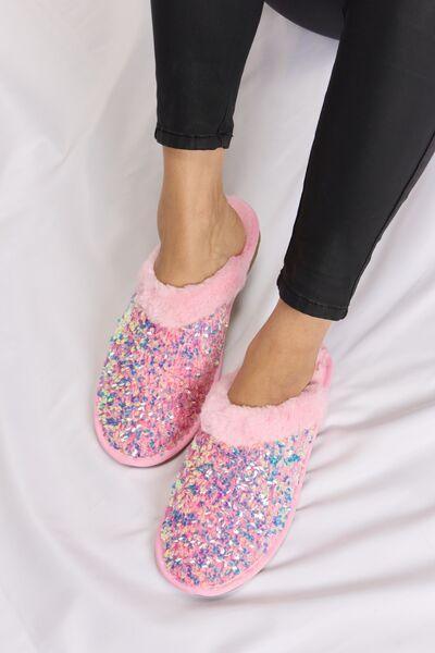 a close up of a person wearing a pair of pink slippers