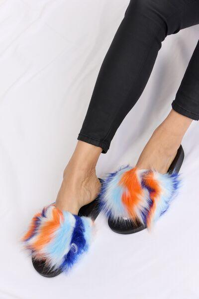 a woman's feet wearing colorful furry slippers
