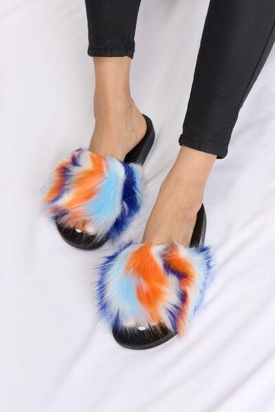 a woman wearing a pair of colorful furry slippers