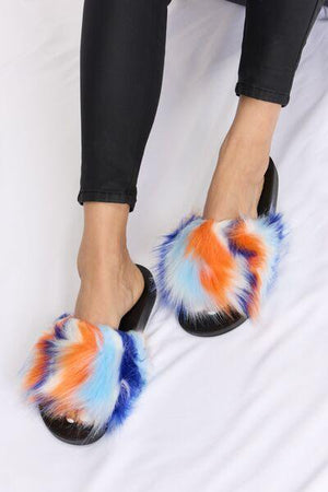 a woman is sitting on a bed wearing a pair of furry slippers