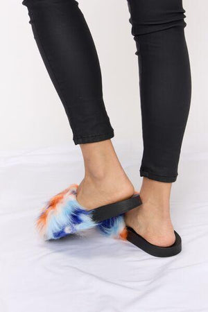 a woman's feet wearing a pair of furry slippers