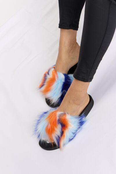 a woman wearing a pair of colorful furry slippers