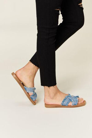 a woman's feet in sandals and jeans