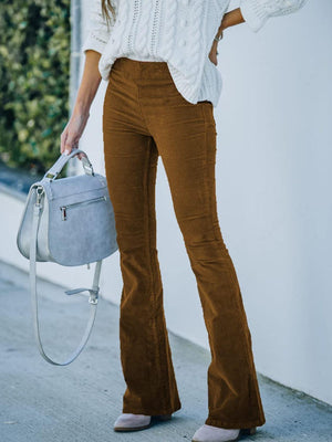 a woman wearing brown pants and a white sweater