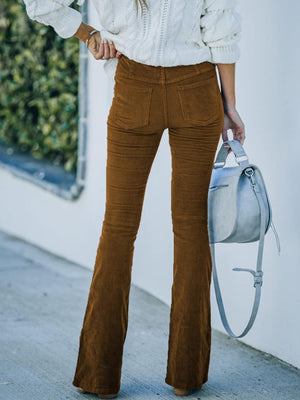 a woman wearing brown pants and a white sweater