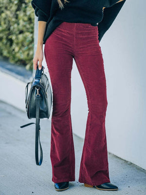 a woman wearing a black sweater and red pants