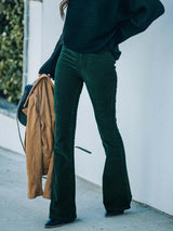 a woman wearing green pants and a black sweater