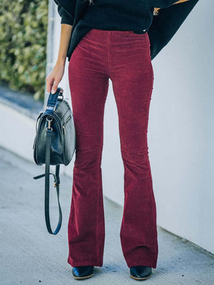 a woman wearing red pants and a black sweater