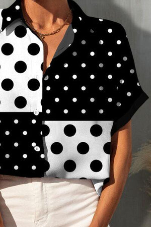 a woman wearing a black and white polka dot shirt