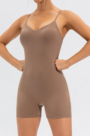 a woman in a tan bodysuit with her hands on her hips
