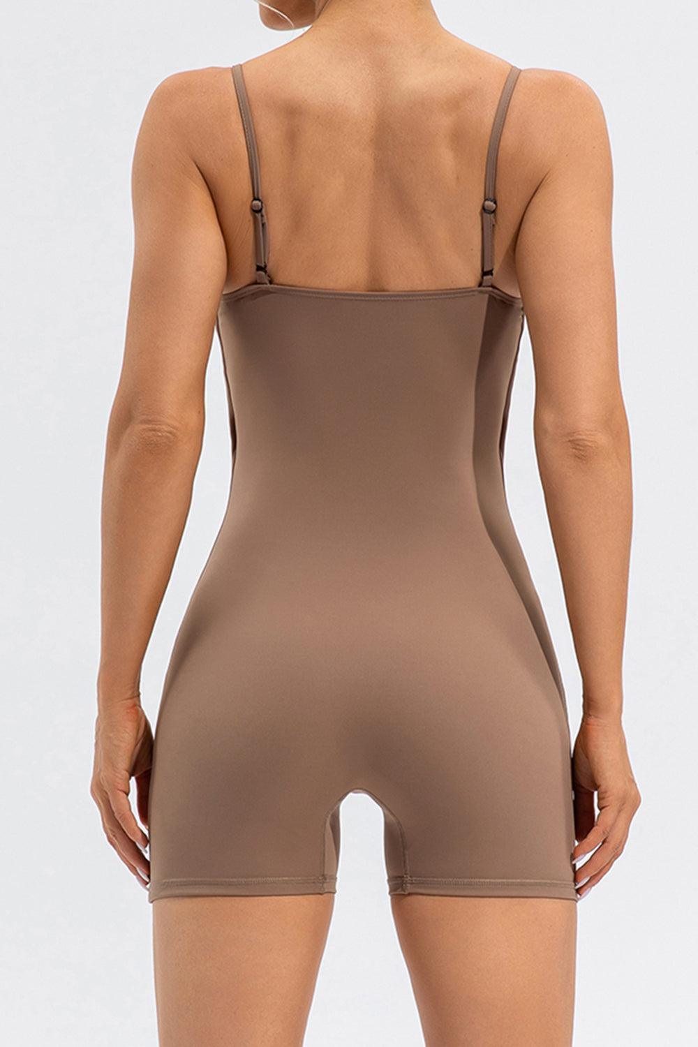 a woman in a tan bodysuit with her back to the camera
