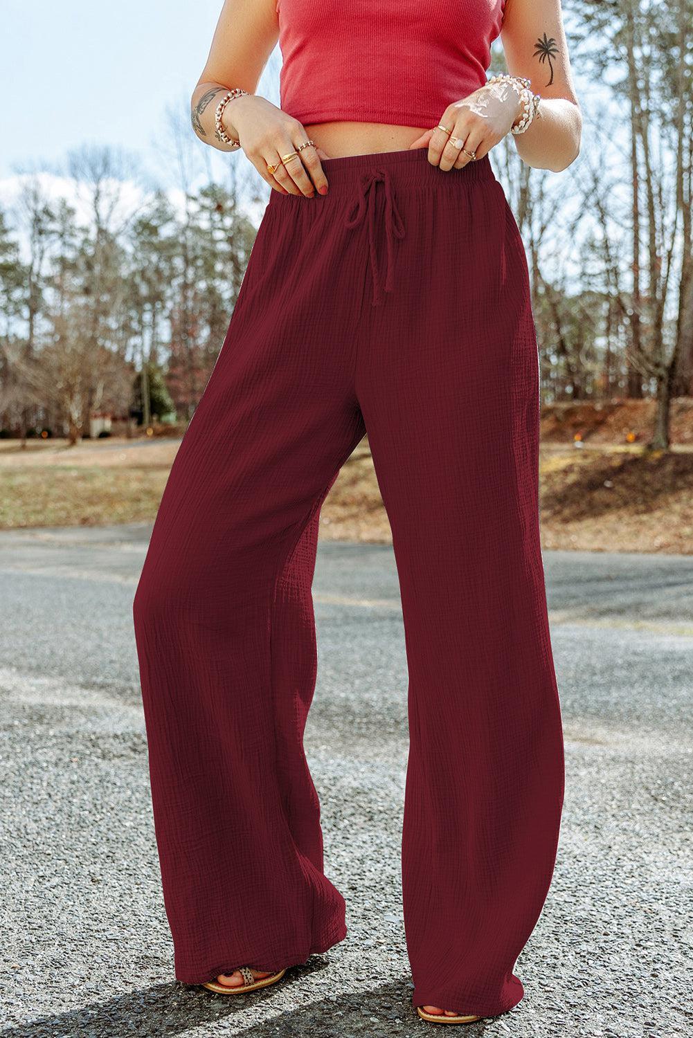 a woman in a red crop top and wide legged pants