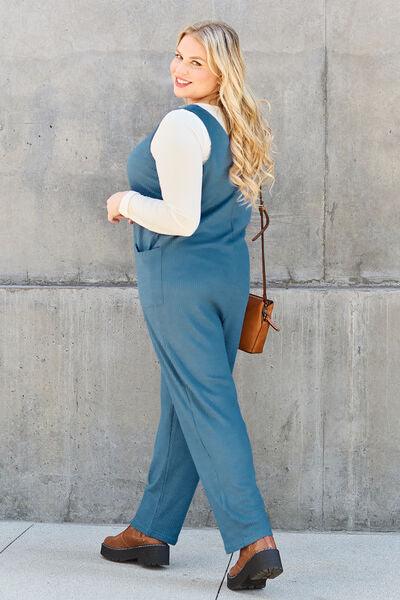 a woman in a blue jumpsuit is walking down the street