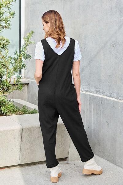a woman wearing a black jumpsuit and white shirt