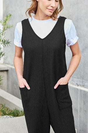 a woman in black overalls and a white shirt
