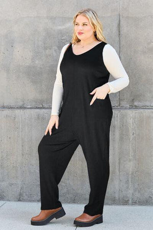 a woman in a black and white jumpsuit posing for a picture