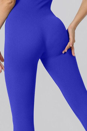 a woman in blue tights holding her butt