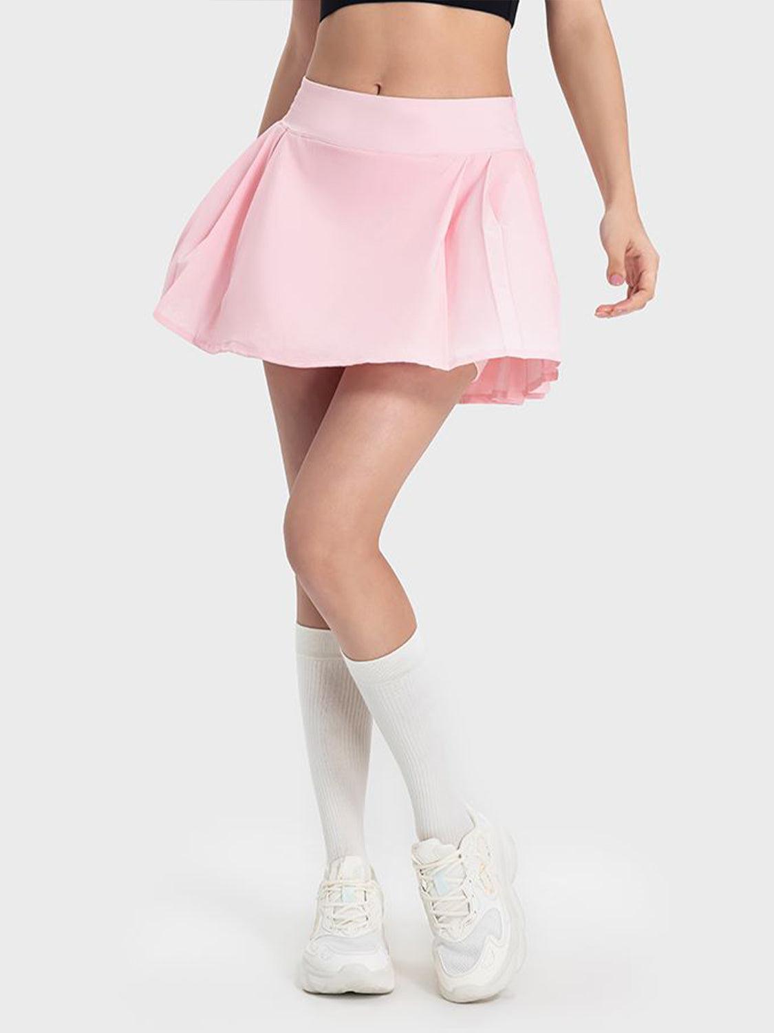 a woman in a pink skirt and crop top