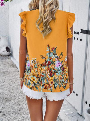 a woman wearing a yellow top with flowers on it