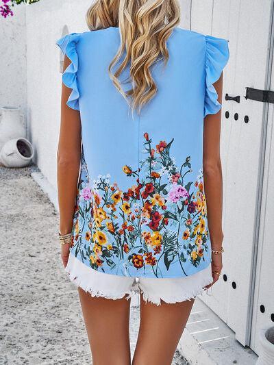 a woman wearing a blue top with flowers on it