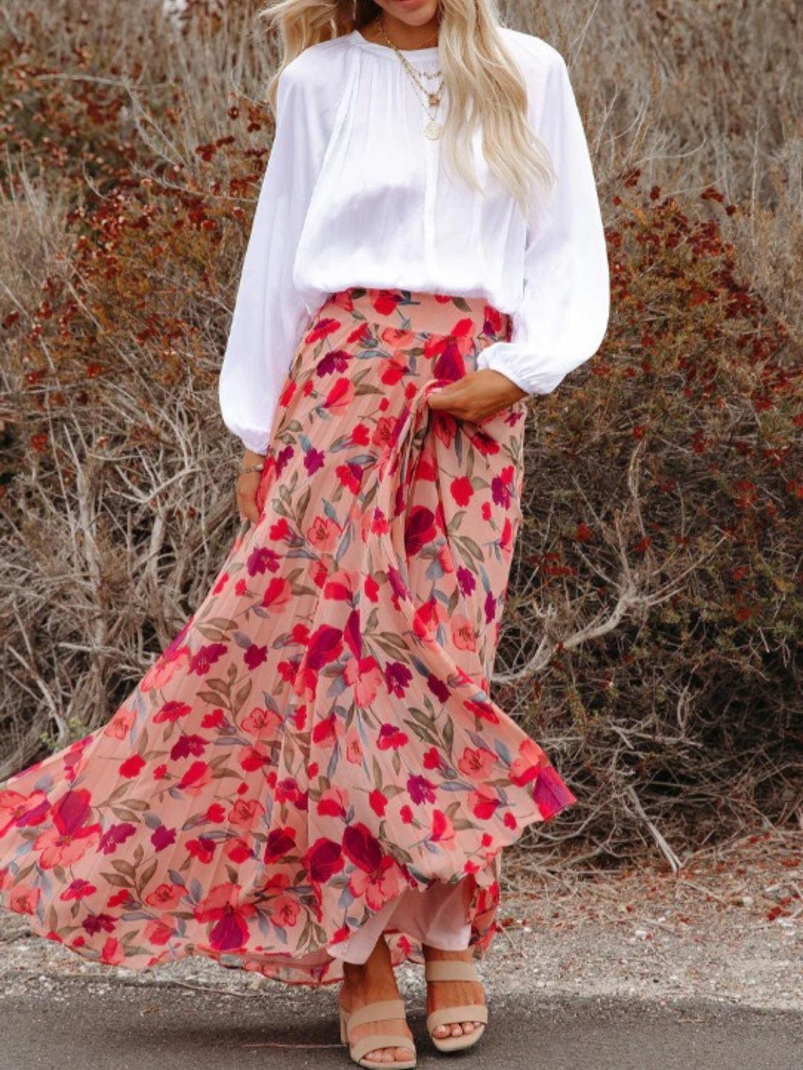 a woman wearing a white shirt and pink floral skirt