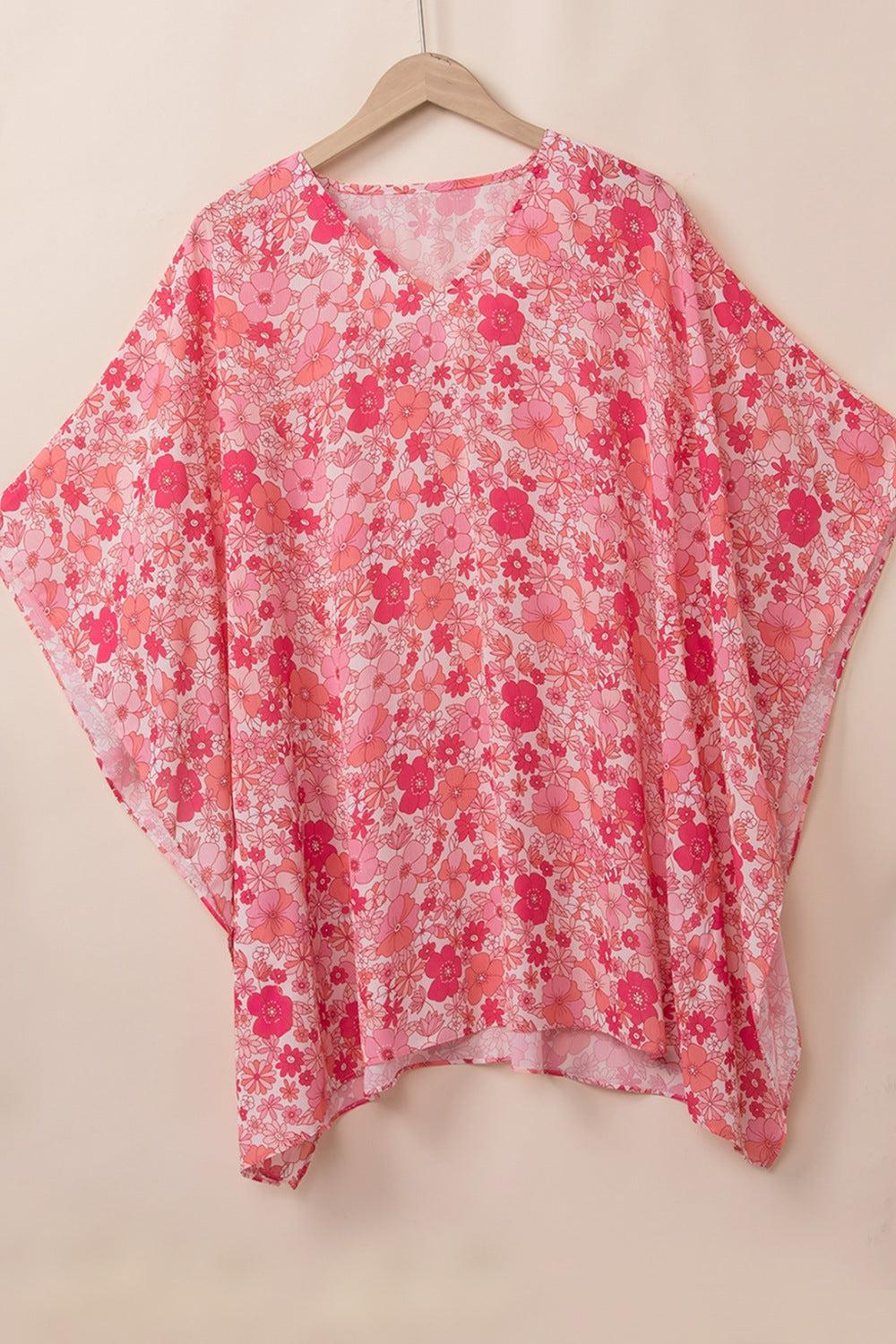 a pink floral top hanging on a hanger