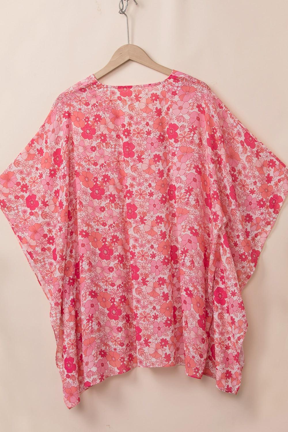 a pink floral top hanging on a hanger