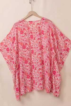 a pink floral top hanging on a hanger