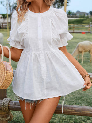 a woman in a white dress standing next to a fence