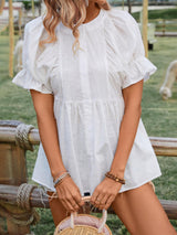 a woman in a white dress holding a straw bag