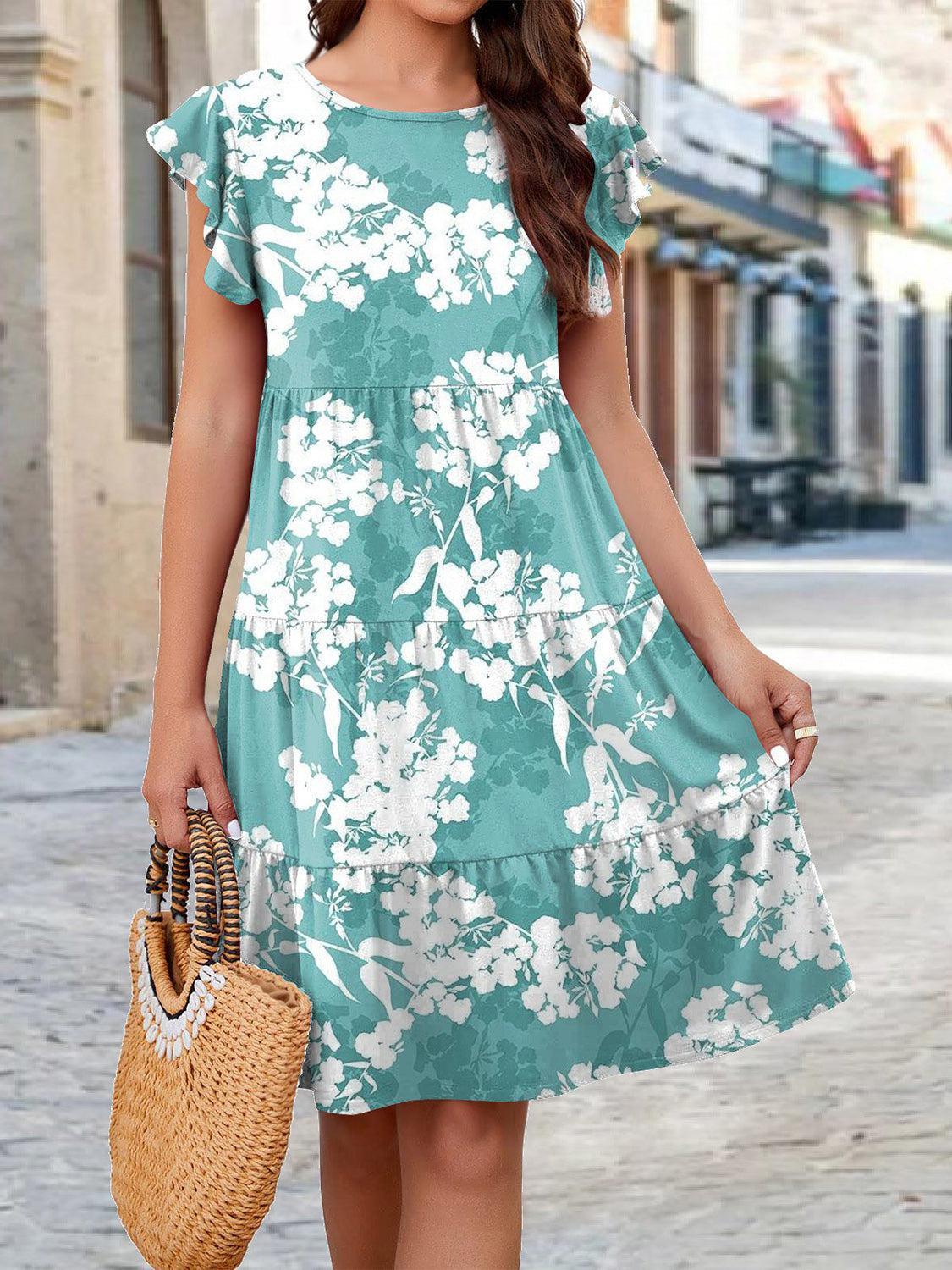 a woman in a blue floral dress holding a straw bag