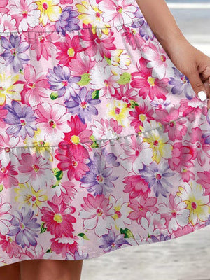 a woman in a pink floral dress holding onto her purse