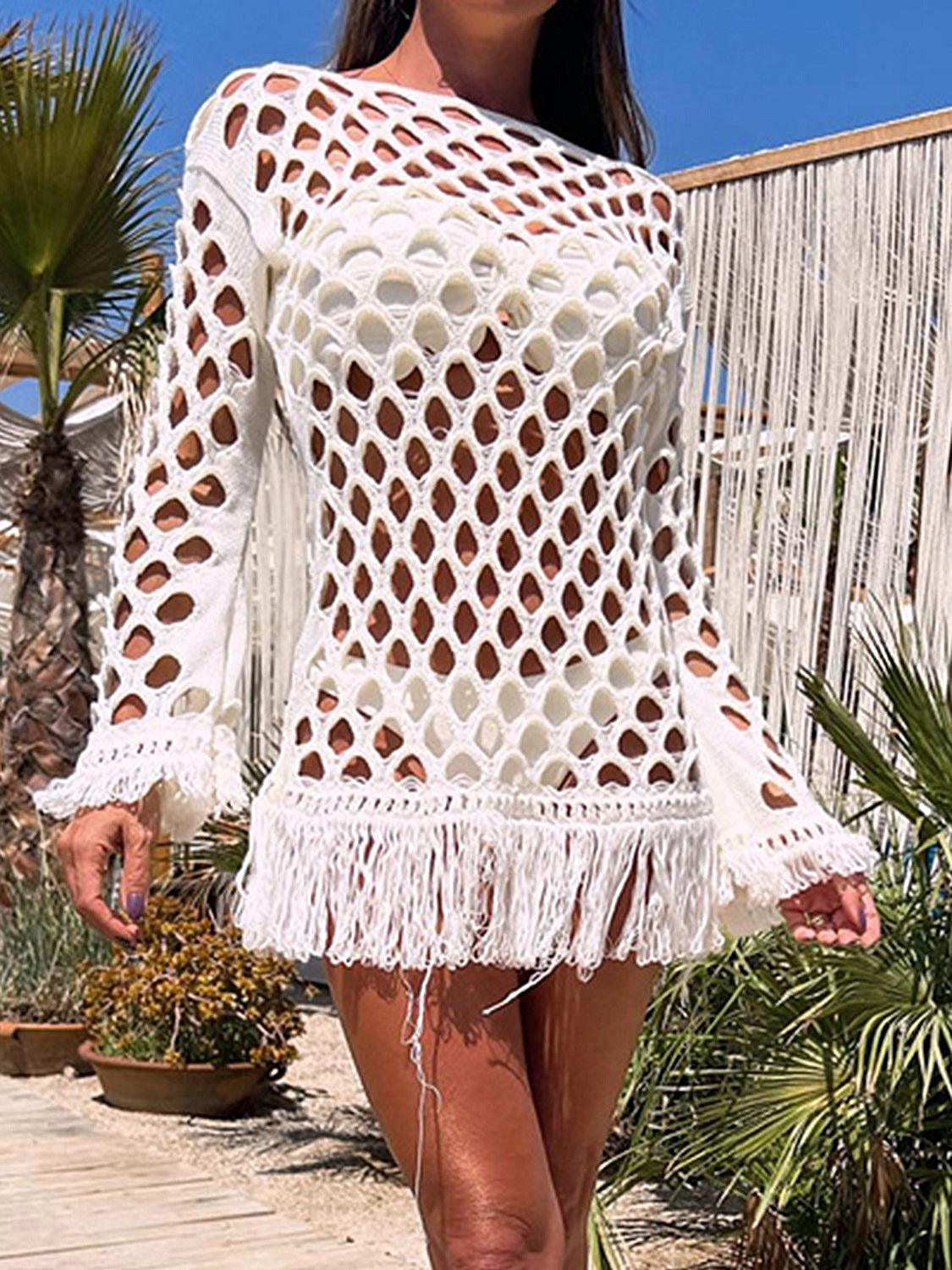 a woman wearing a white crochet sweater and shorts