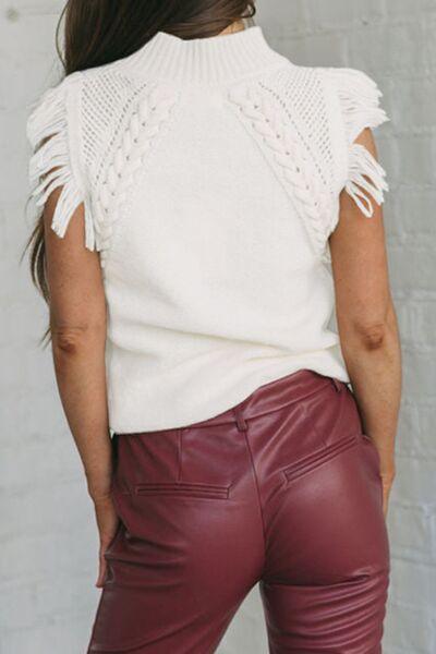a woman wearing a white sweater and maroon leather pants