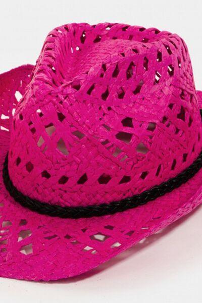 a pink cowboy hat with a black ribbon around the brim