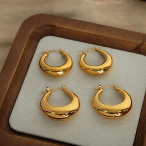 four pairs of gold hoop earrings in a wooden box