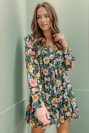 a woman in a floral dress posing for a picture