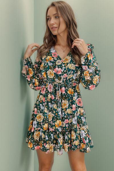 a woman in a floral dress posing for a picture