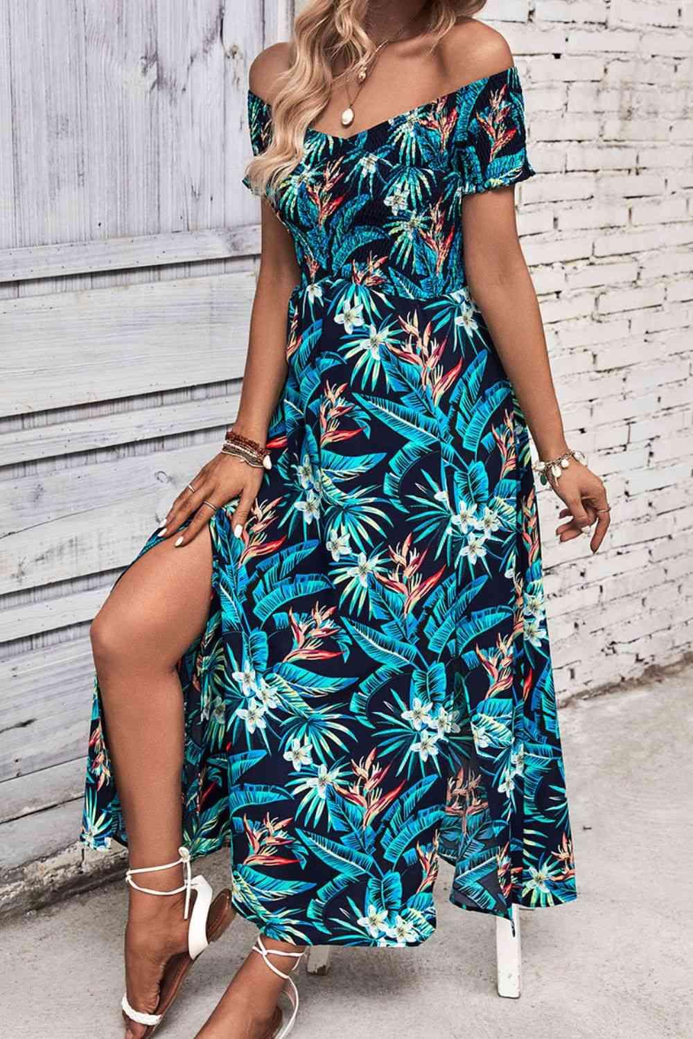 a woman wearing a blue tropical print dress
